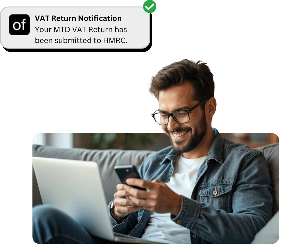 Smiling man in glasses looking at his phone with a laptop on his lap, next to a notification from Online Filings confirming VAT return submission to HMRC.